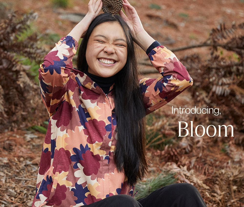 Model smiling wearing the Elements Jacket in Bloom, made by artist Izzy Lawrence