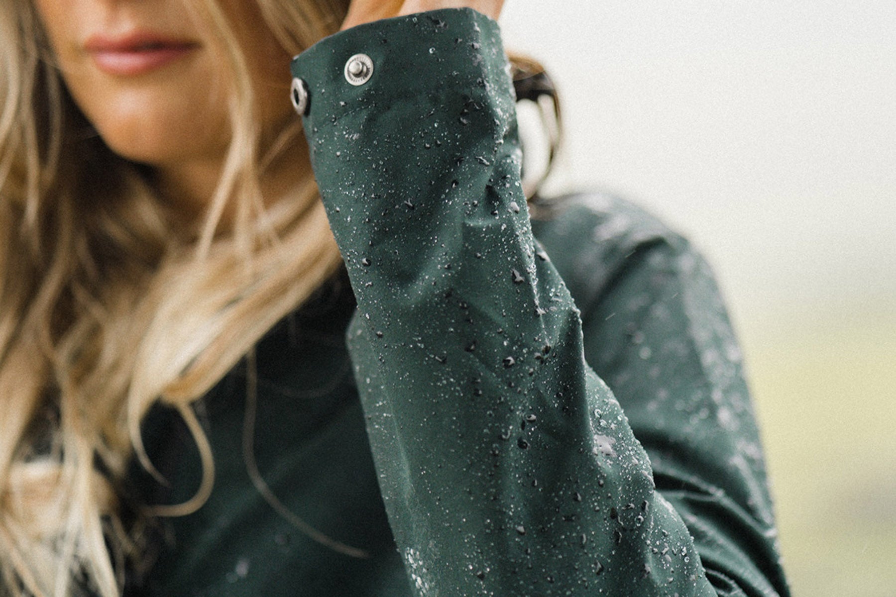 A woman wearing the Amble Refuge Jacket in the rain